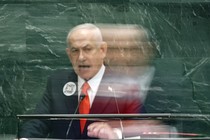 Photograph of Benjamin Netanyahu speaking at the U.N. podium with his image blurred, as if moving quickly