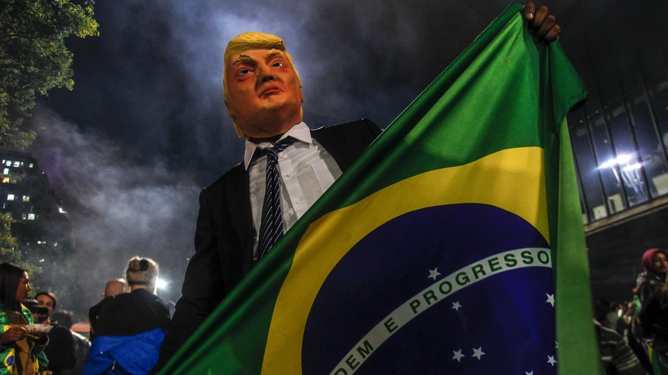 A supporter of Jair Bolsonaro wears a mask of Donald Trump as he celebrates after Bolsonaro won Brazil's presidential election on Oct 28, 2018