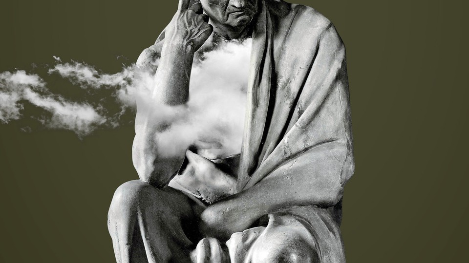 Photograph of a statue of a man thinking with clouds floating over part of the statue
