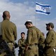 Soldiers gather around an Israeli flag as they receive a briefing near the border with Gaza.