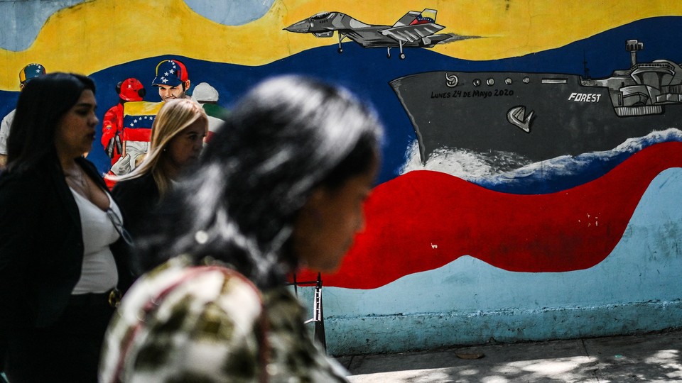 People walk past a mural of a Venezuelan warship and warplane in Caracas.