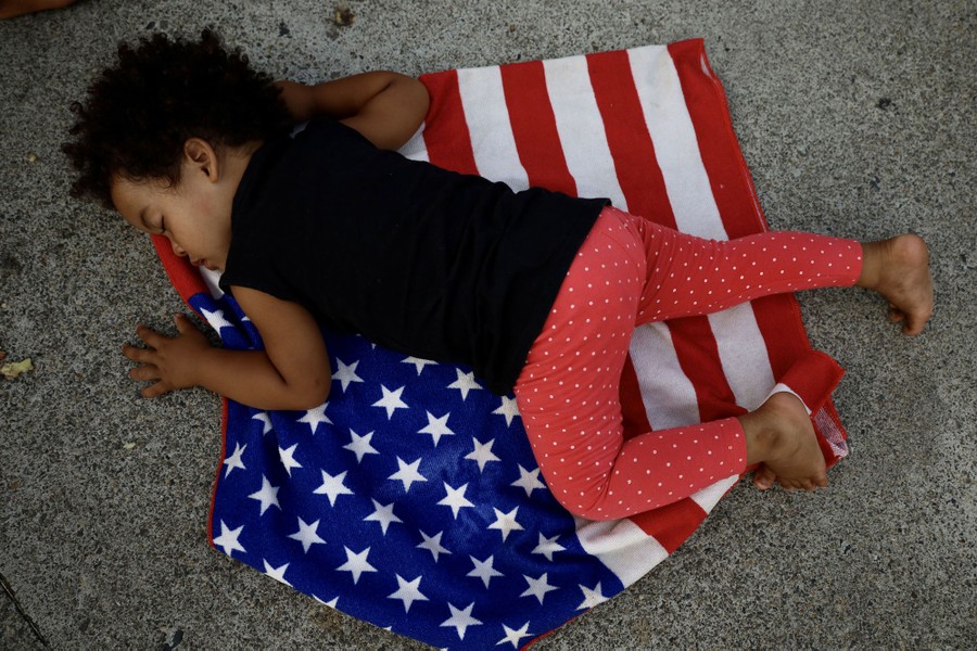 A child sleeps on a folded American flag.