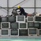 An employee arranges discarded televisions at an electronic waste recycling factory in Wuhan, China, in 2011.