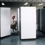 An office worker at a cubicle. He looks bored.