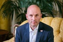 photograph of Spencer Cox in a yellow chair