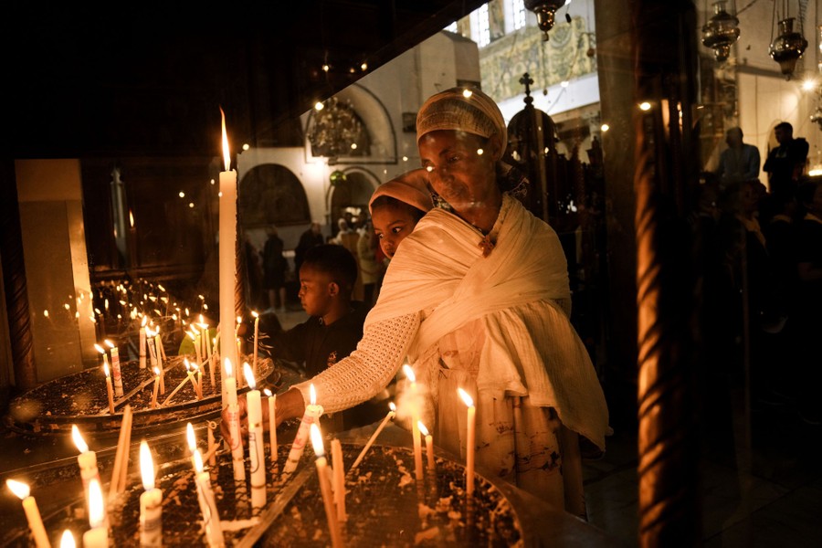 People light candles inside a church.