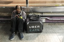 An Uber Eats worker checks his mobile phone in São Paulo.