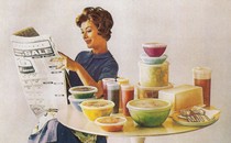 A woman sits at a table with tupperware circa 1960s.