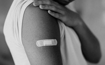 Photo of someone's upper arm with a post-injection Band-Aid