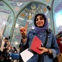 An Iranian woman shows her inked finger after casting her ballot at a polling station in Tehran on February 26, 2016. 