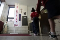 Students at a Catholic school pass a statue of the Virgin Mary and a crucifix on their way to class. 