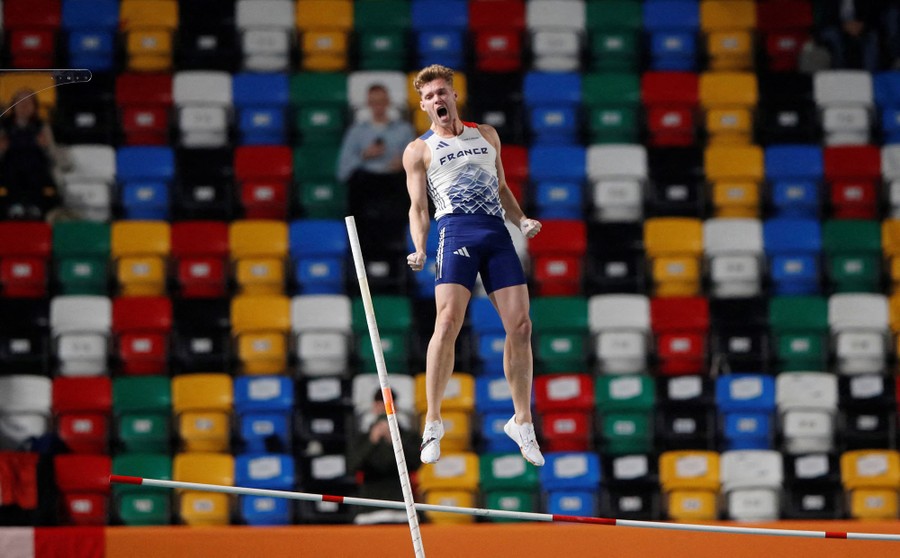 A pole vaulter reacts while falling from a jump.