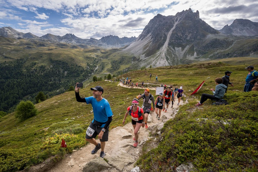 A line of competitors races along a path high in the mountains.