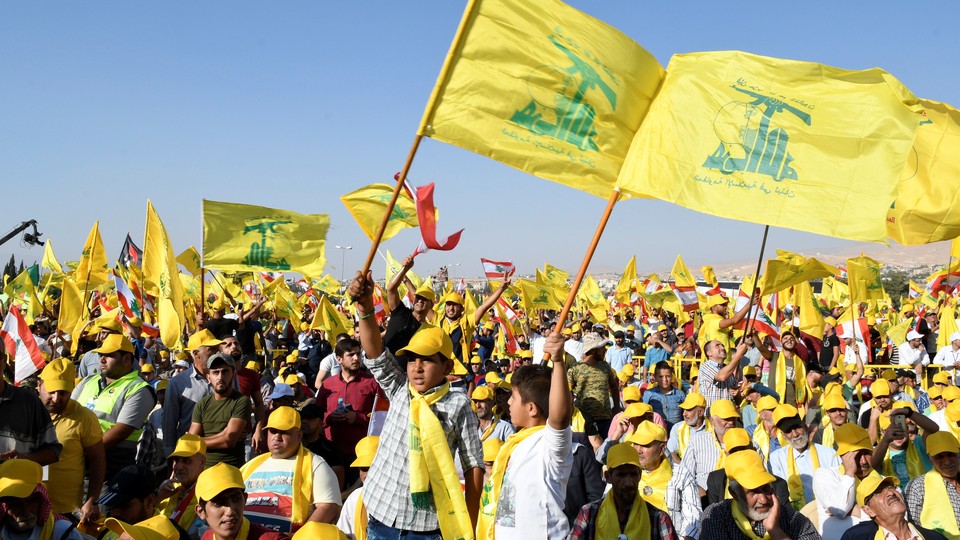 Supporters of Lebanon's Hezbollah leader Sayyed Hassan Nasrallah display Hezbollah and Lebanese flags.