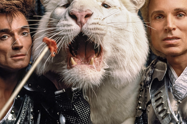 A photograph of Siegfried & Roy feeding a white tiger