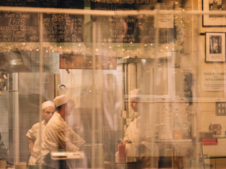 workers in a restaurant seen through a window
