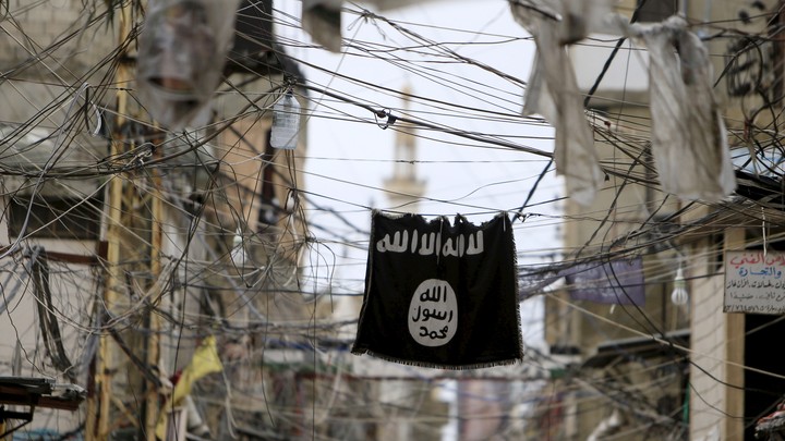 An Islamic State flag hangs amid electrical wires over a street in Lebanon.
