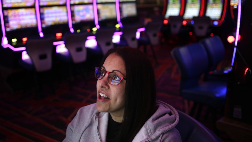 A woman wearing glasses looks up at a screen