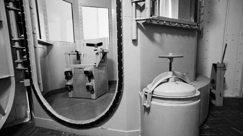 A black-and-white photo looking into a gas chamber in a San Quentin, California prison