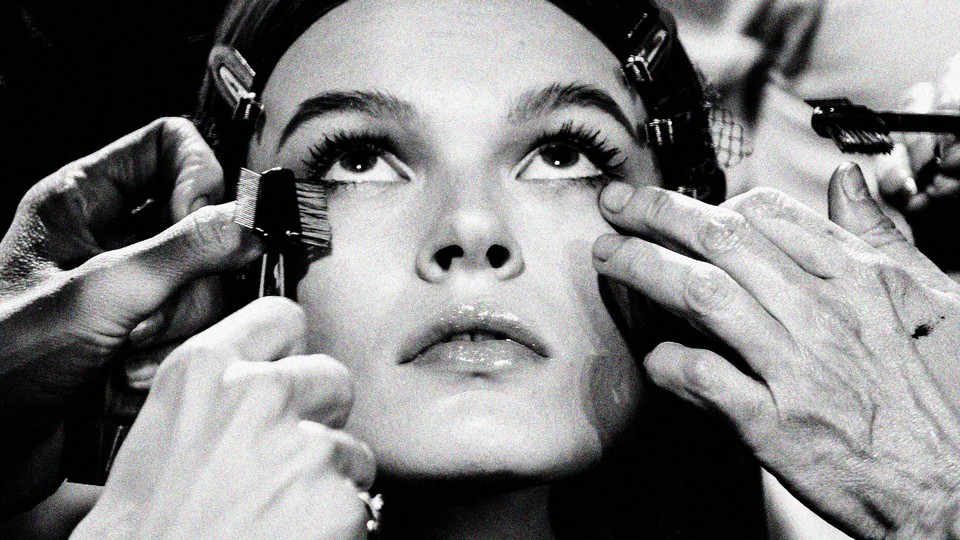 A close up of a woman having make up applied to her face