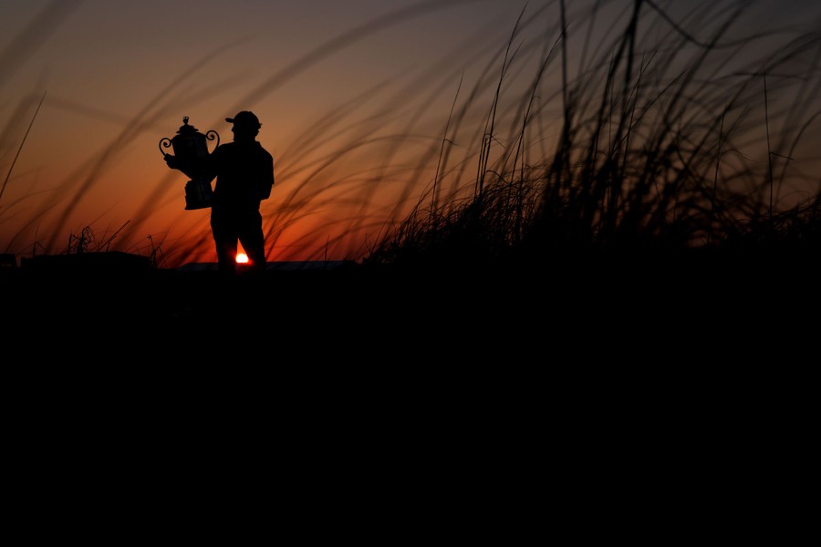A silhouette of a man holding a trophy.