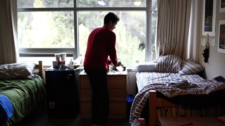 A student in his college dorm room on campus