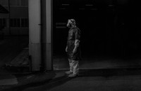 A person in a protective suit stands in the dark.