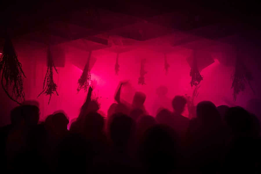 People dance together in a dark, misty room.