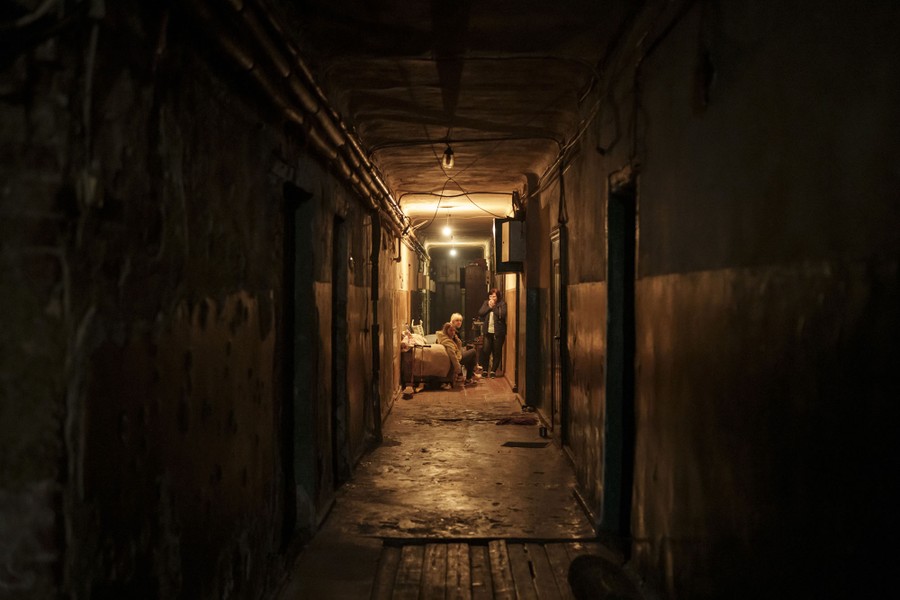 A small family sitting in a dark hallway.