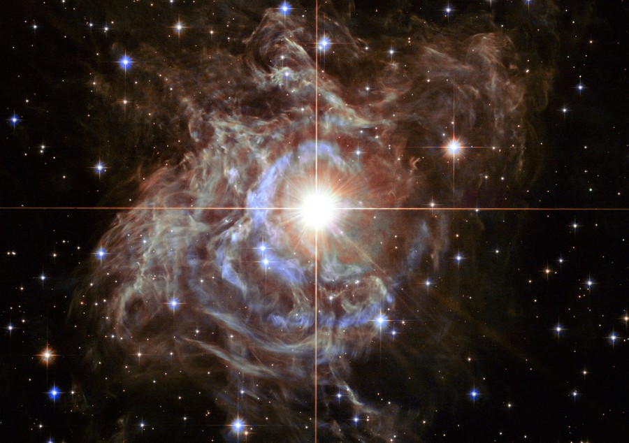 A very bright star sits nested in a swirling cloud of gas.