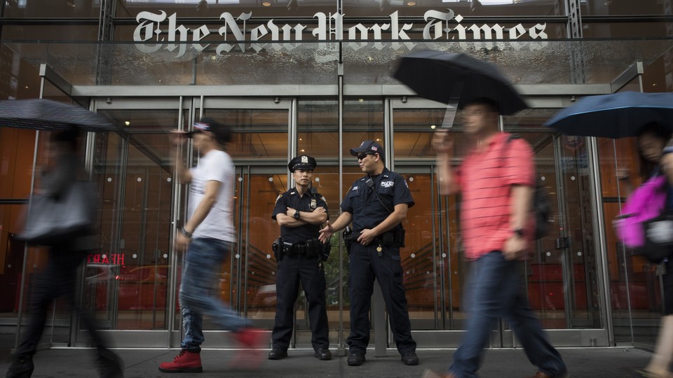 Members of the New York City Police Department stand outside the headquarters of The New York Times.