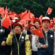 A large group of people wave Chinese flags.
