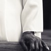 close-up of a hand resting on a pew