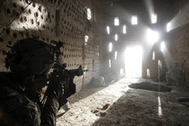 An American soldier points his rifle at a doorway after coming under fire by the Taliban while on patrol in Kandahar province in April 2012.
