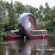 An art installation made of a canal boat that has apparently been twisted into a loop in the middle