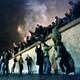 East German citizens climb over the Berlin Wall into West Berlin. 