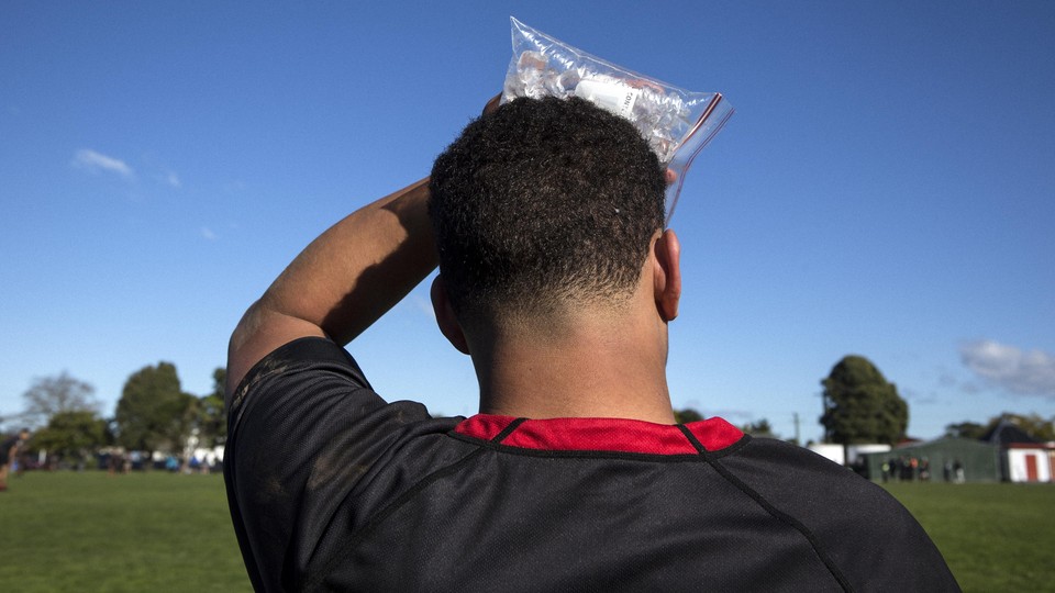 A soccer player holding a bag of ice to his head.