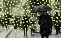 Photo of someone, masked, on the street with an umbrella; glowing dots overlaid like snow