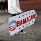 A person holds an Obamacare sign