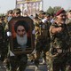 Members of the Abbas combat squad, a Shiite militia group, carry a picture of Grand Ayatollah Ali al-Sistani.