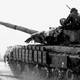 Two people sit atop a tank in Ukraine in 2022.