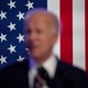A blurry picture of Biden, the American flag in the background