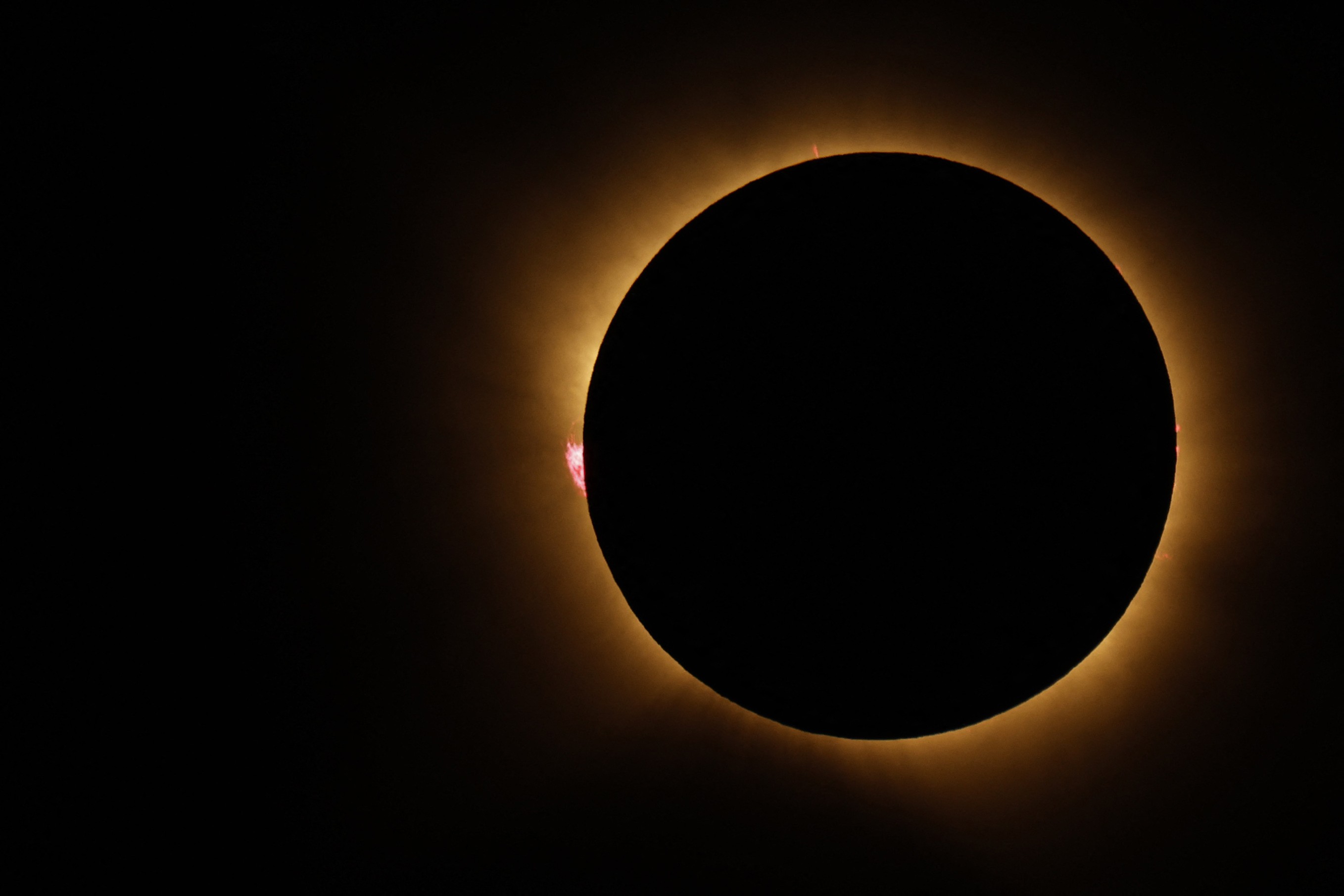 The Sun’s corona glows as the moon completely blocks the sun.