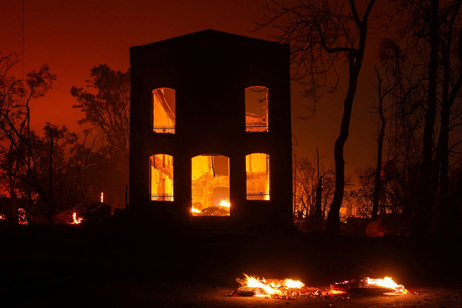 The burned-out shell of a building, seen during a wildfire.