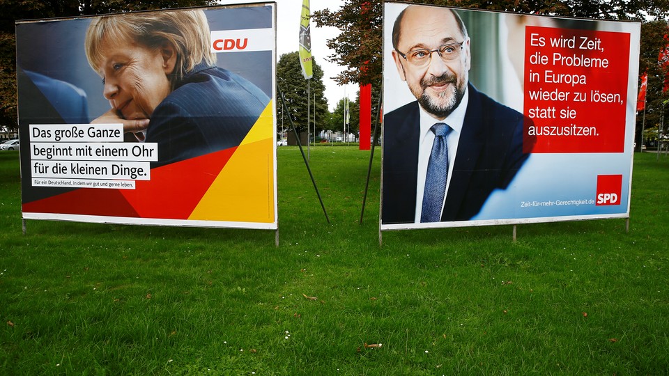 Election campaign posters show Angela Merkel and Martin Schulz side by side on the grass.