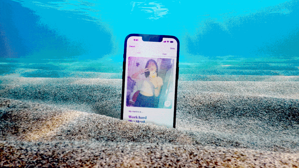 GIF of an iPhone sitting on sand underwater, scrolling through Hinge profiles.