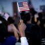 A new citizen waves an American flag during a naturalization ceremony.