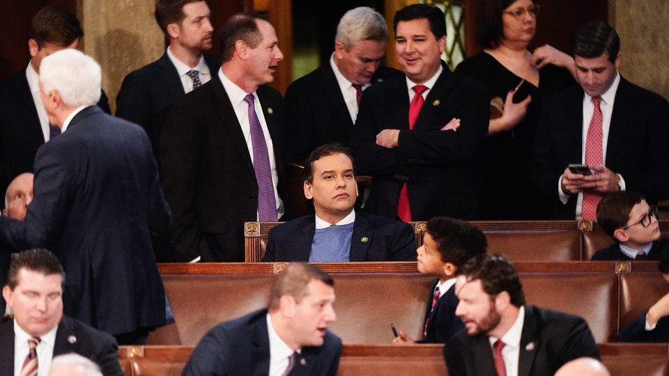 A photo of George Santos sitting alone as many congresspeople converse around him
