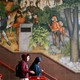 Two students walk down steps past a historical mural at George Washington High School in San Francisco.