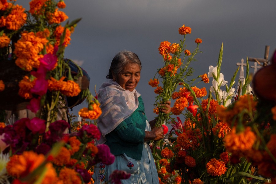 A person places flowers on a grave.